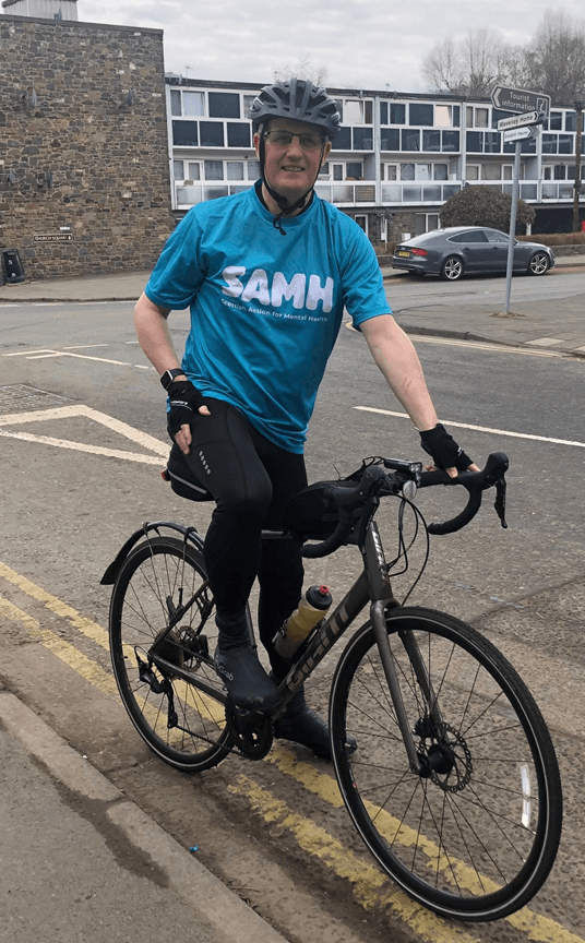 Ralph Roberts on a bike in a blue t-shirt.
